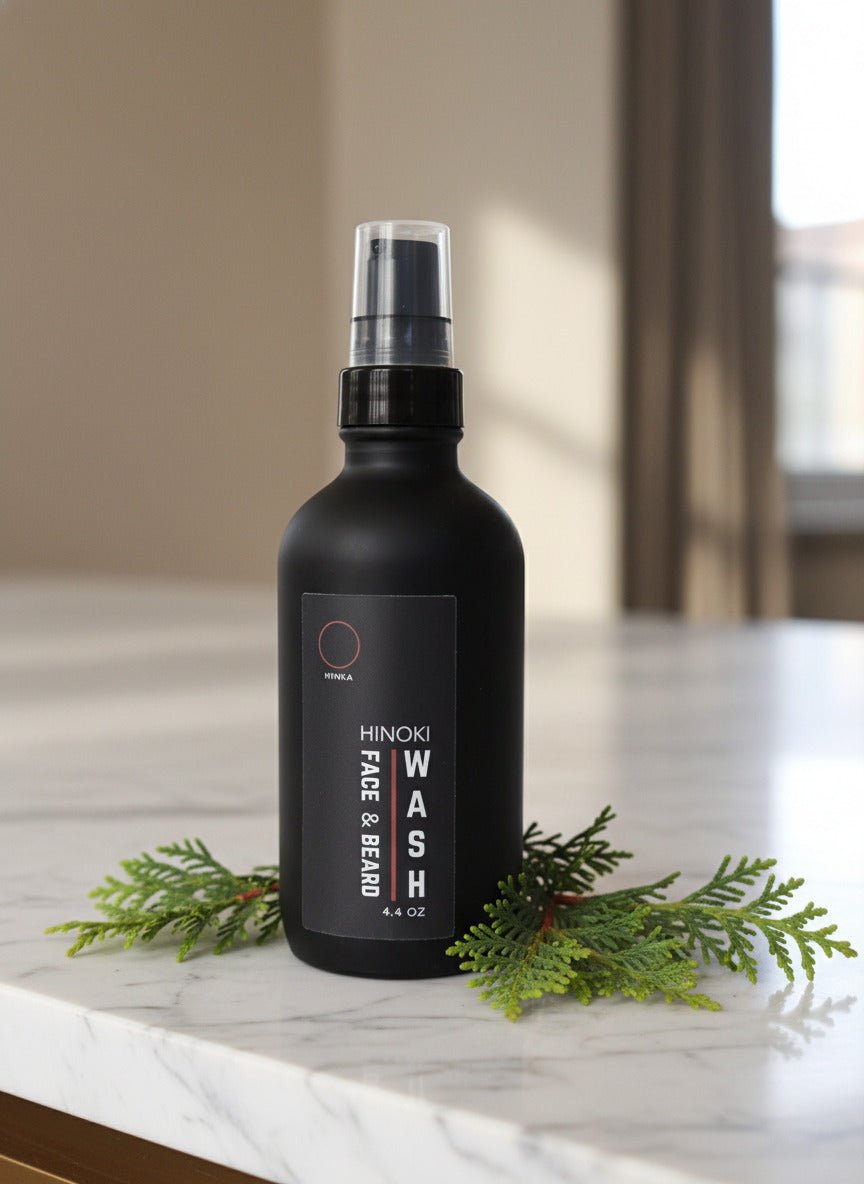 A black bottle of Hinoki Face & Beard Wash with a spray nozzle, labeled 4.4 oz (130 ml).