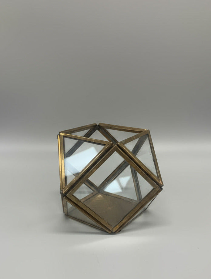 Geometric glass wall sconce on a white wall with wooden paneling.