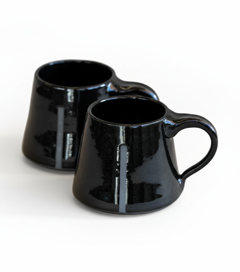 Two black ceramic mugs on a white background