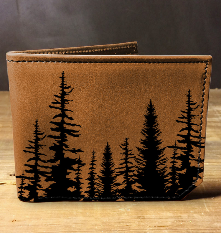 Brown leather wallet with black tree pattern on a wooden surface