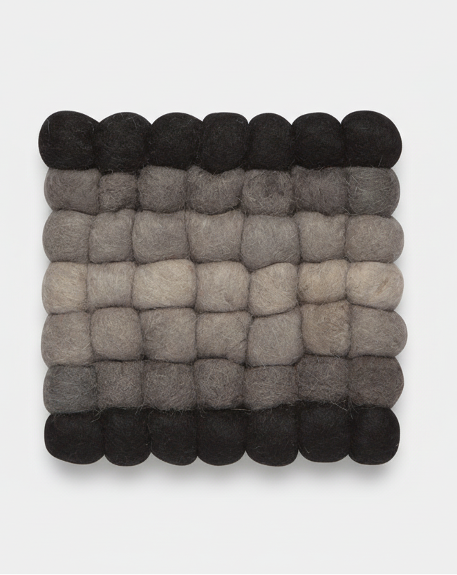 Square woven mat with black, gray, and beige colors on a light gray background