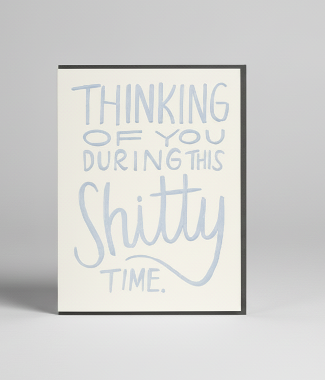 Framed print with text 'Thinking of you during this shitty time.' on a textured wall.