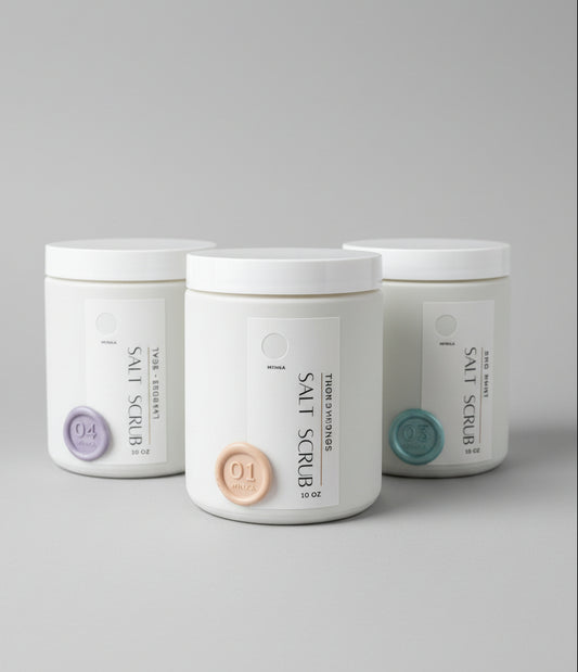 Three bottles of salt scrub on a wooden surface
