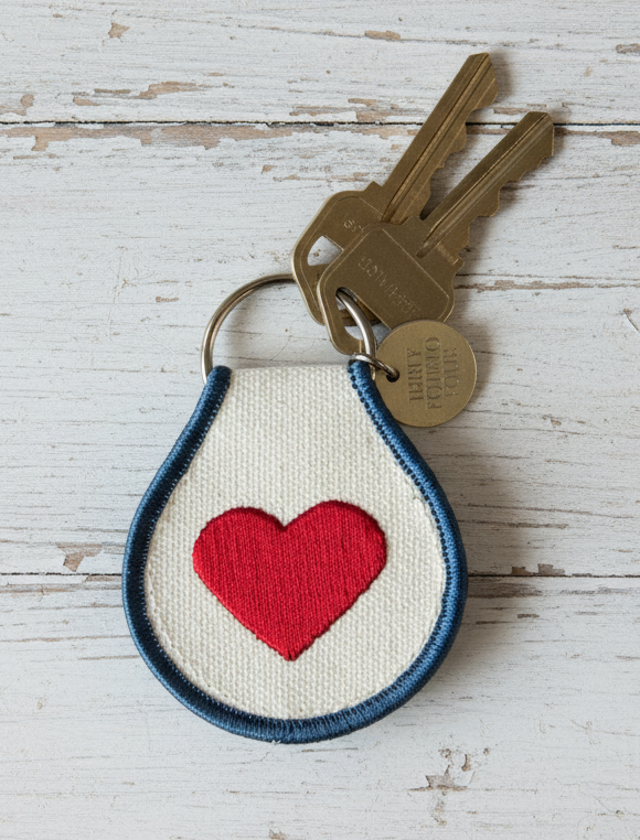 Keychain with red heart design on a wooden surface