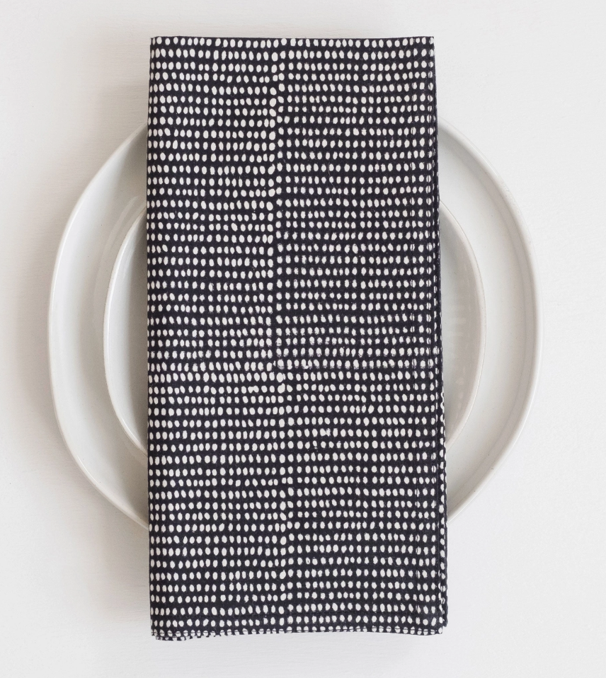 Black and white patterned napkin on a white plate with a white background