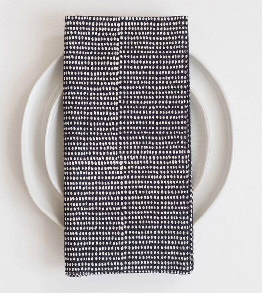 Black and white patterned napkin on a white plate with a white background