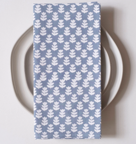 Blue napkin with white leaf pattern on a white plate
