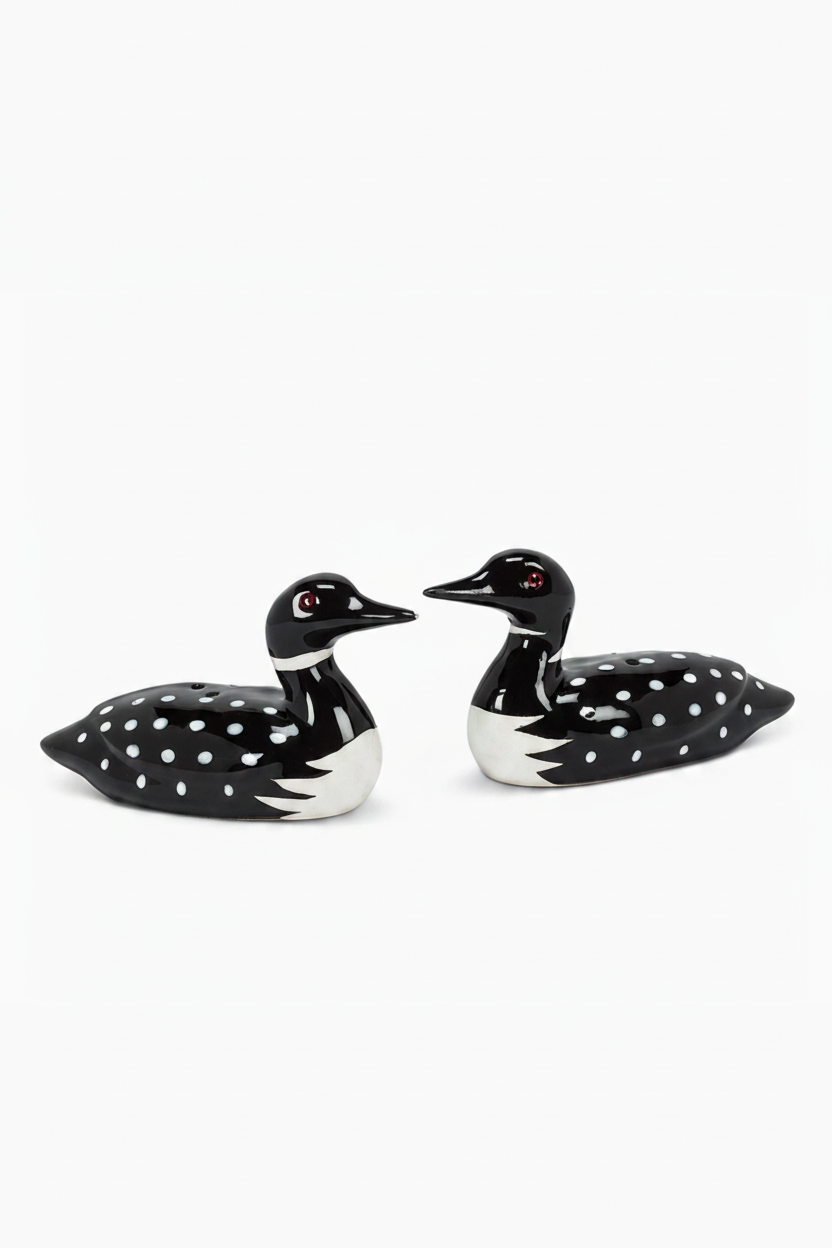 Two black and white ceramic loon figures on a white background
