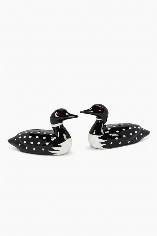 Two black and white ceramic loon figures on a white background