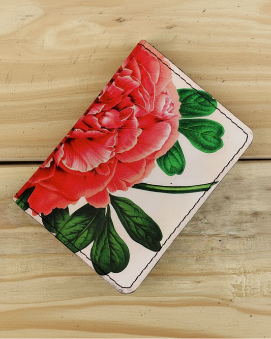 Floral wallet with red flowers and green leaves on a wooden surface