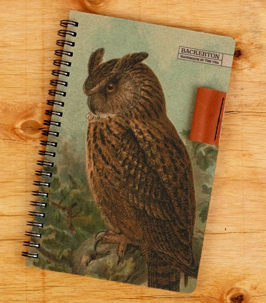 Notebook with owl design on a wooden surface