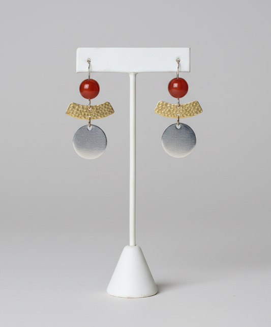 Pair of earrings on a white stand against a plain background