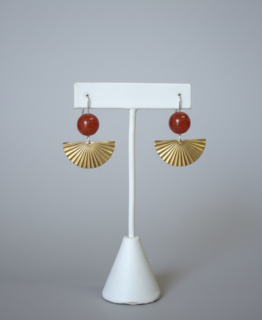 Pair of earrings on a white stand with a plain background