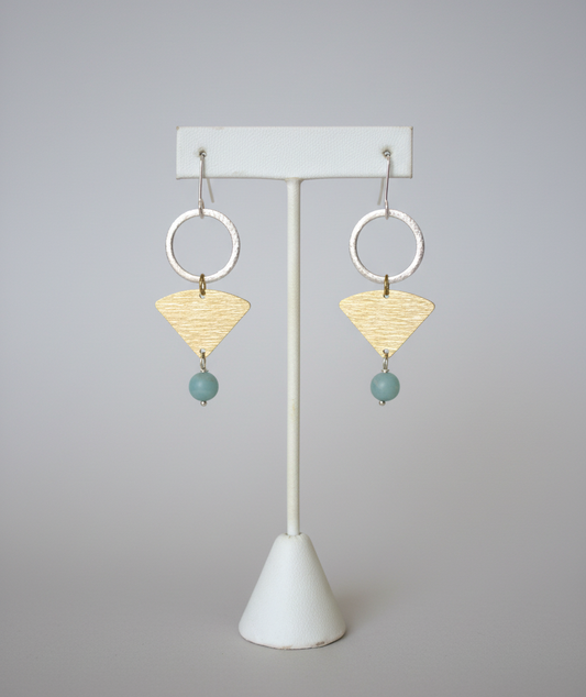 Pair of earrings on a white stand with a plain background