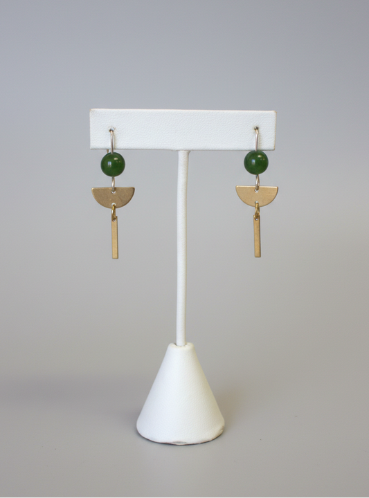 Pair of earrings on a white stand with a plain background