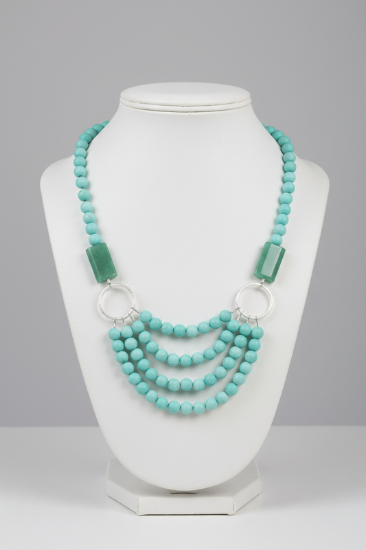  amazonite beaded necklace with green rectangular beads on a wooden stand.