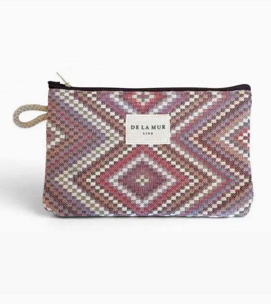 A Delamur zippered pouch featuring a geometric diamond pattern in shades of pink, purple, beige, and brown, with a white brand label on the front.