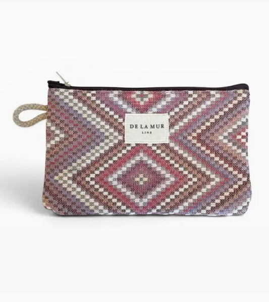 A Delamur zippered pouch featuring a geometric diamond pattern in shades of pink, purple, beige, and brown, with a white brand label on the front.