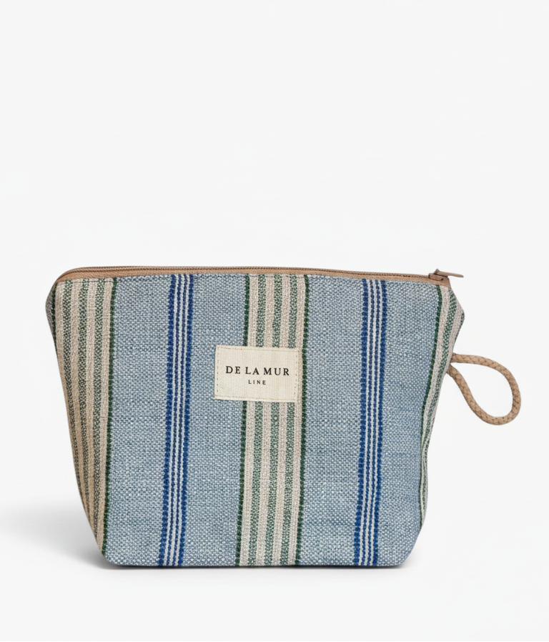 A zippered pouch featuring a blue, green, and beige striped woven fabric body, a beige brand label on the front, and a natural jute loop handle, set against a plain white background.