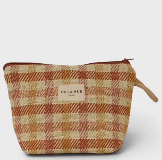 A small woven zip pouch with a plaid pattern in beige, rust orange, and brown, featuring a central cream label that reads 'DE LA MUR LINE'.