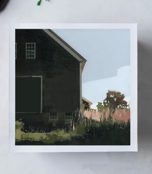 Framed artwork of a house with a blue sky and trees on a white surface