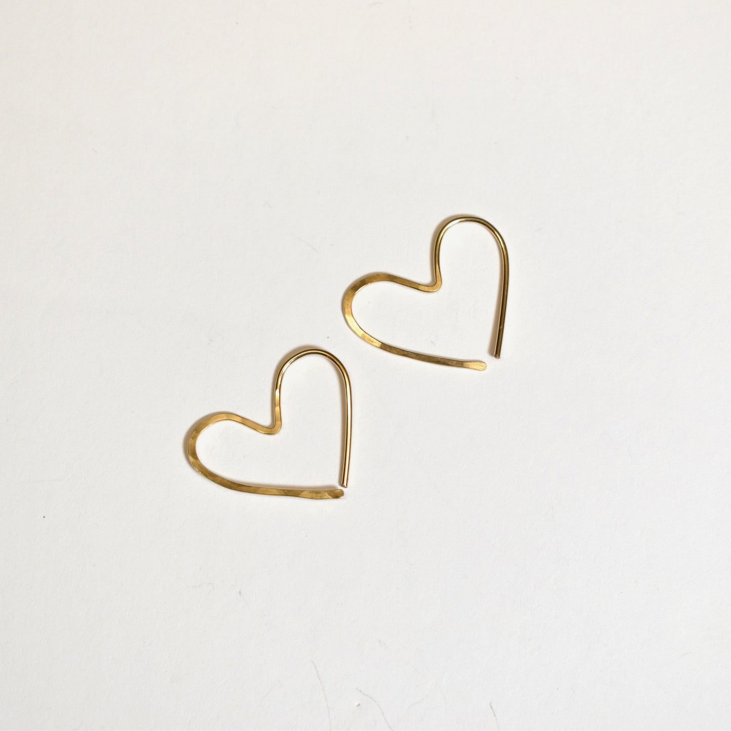 Heart earrings featuring gold filled hammered hoops. Designed and handmade in Maine by Lynne Stewart Designs.